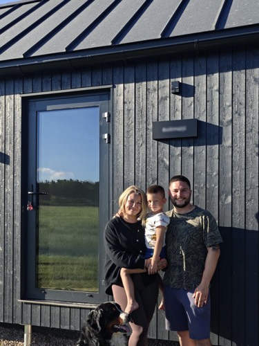 MyCabin homeowners with their dog outside their new home