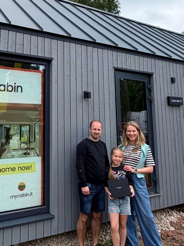 MyCabin homeowners with their daughter outside their new home